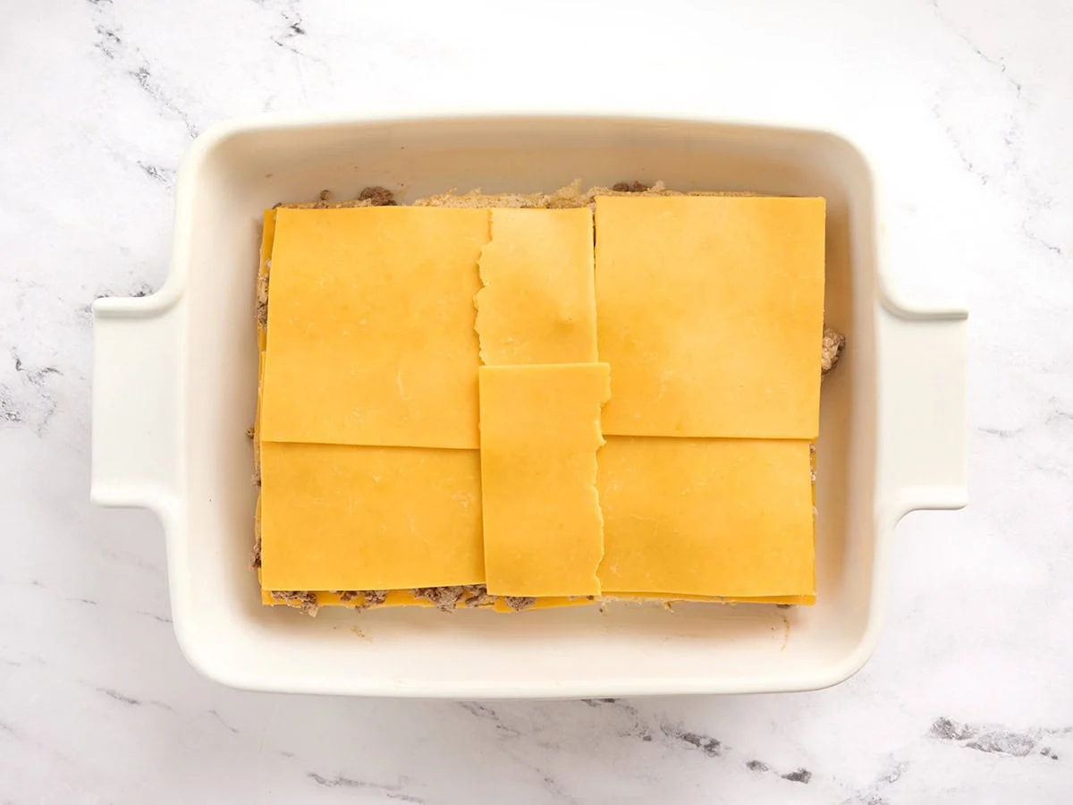 Se agrega otra capa de queso a las hamburguesas de carne.