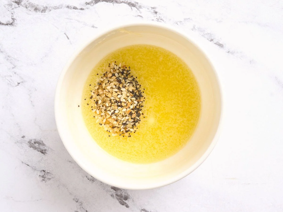 Un bol de mantequilla derretida con condimentos añadidos.