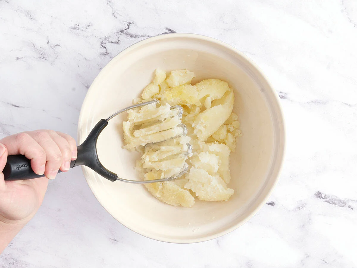 Triturar las patatas.