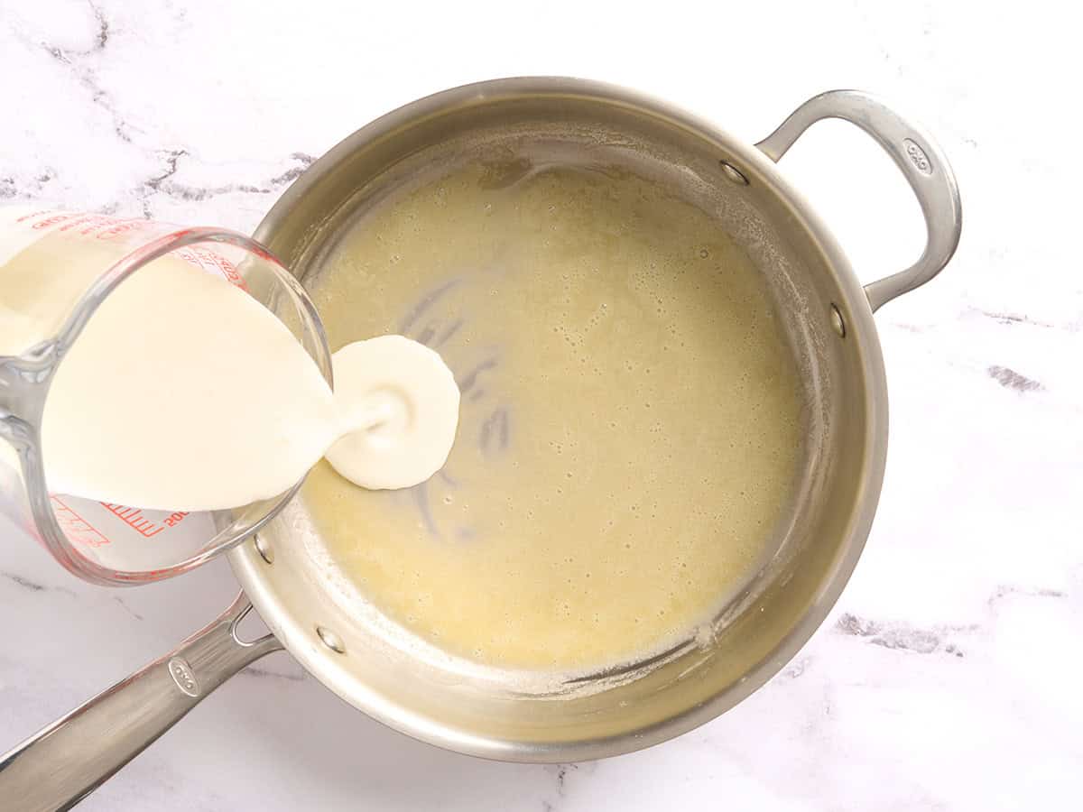 Se vierte la crema en un roux en una sartén.