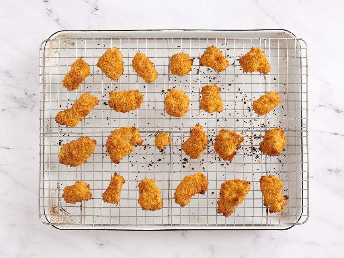 Nuggets de pollo caseros terminados sobre una rejilla después de hornearlos.