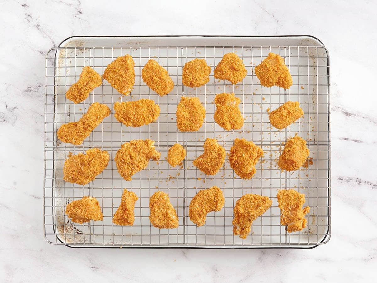 Nuggets de pollo rebozados sobre una rejilla.