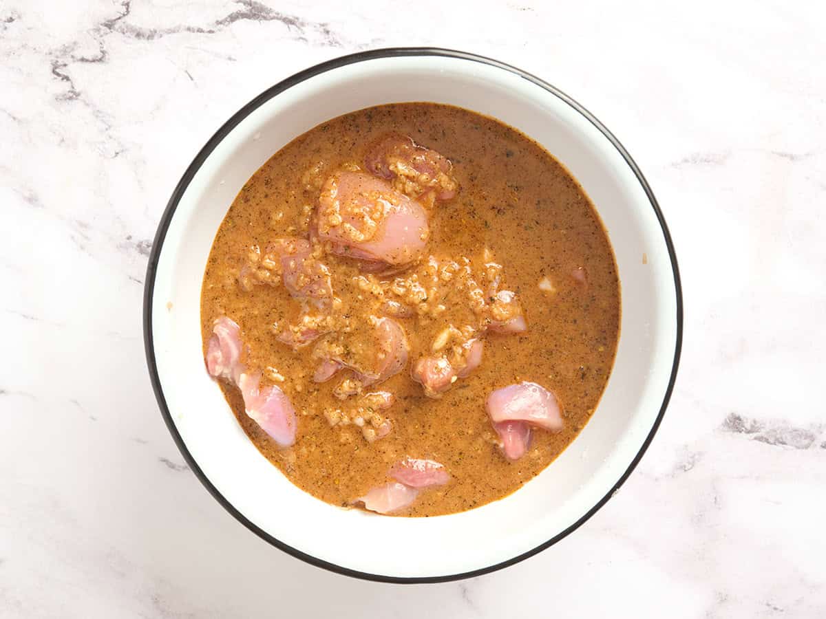 Trozos de muslo de pollo marinados en adobo de yogur.