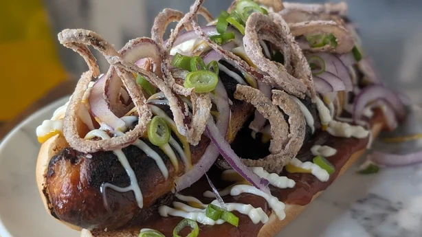 Un hot dog cargado de aderezos
