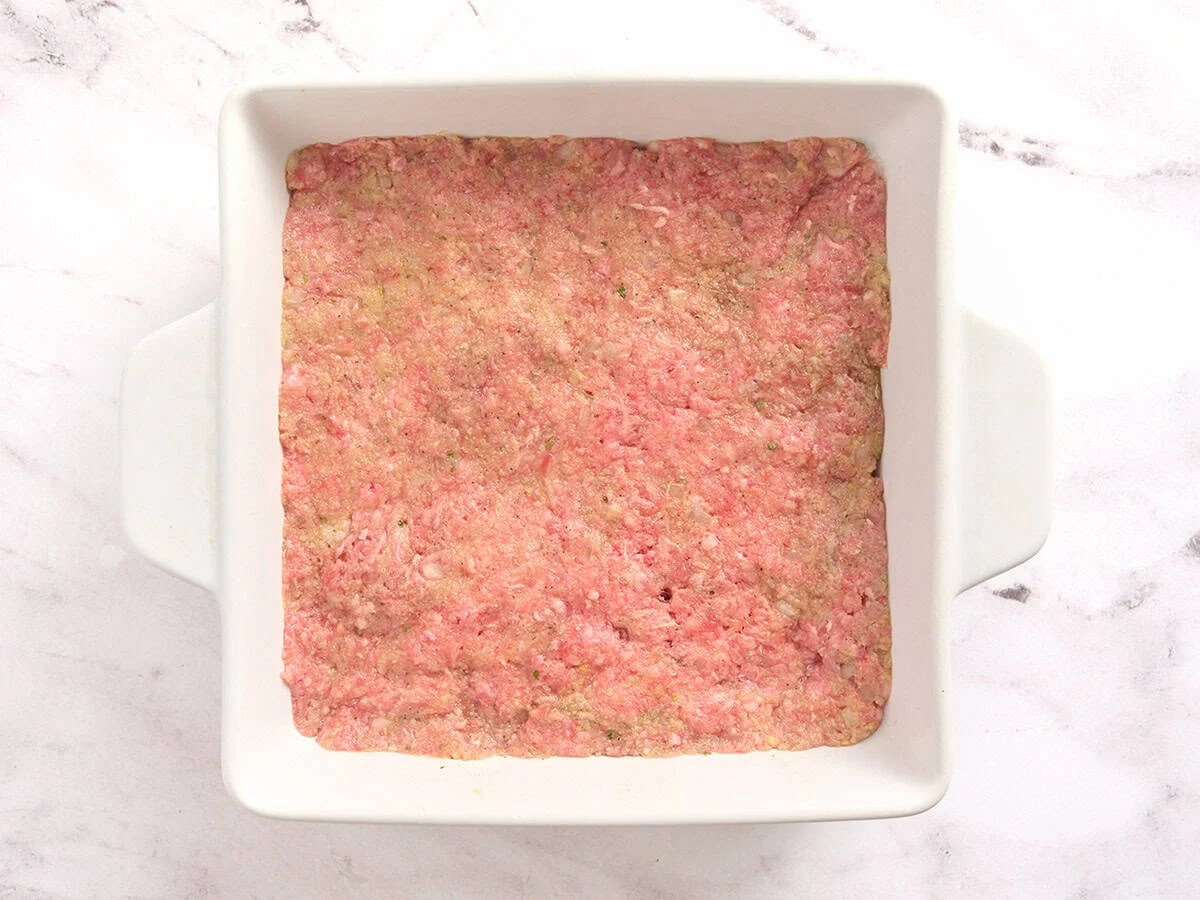 Mezcla de pastel de carne en una fuente para horno cuadrada.