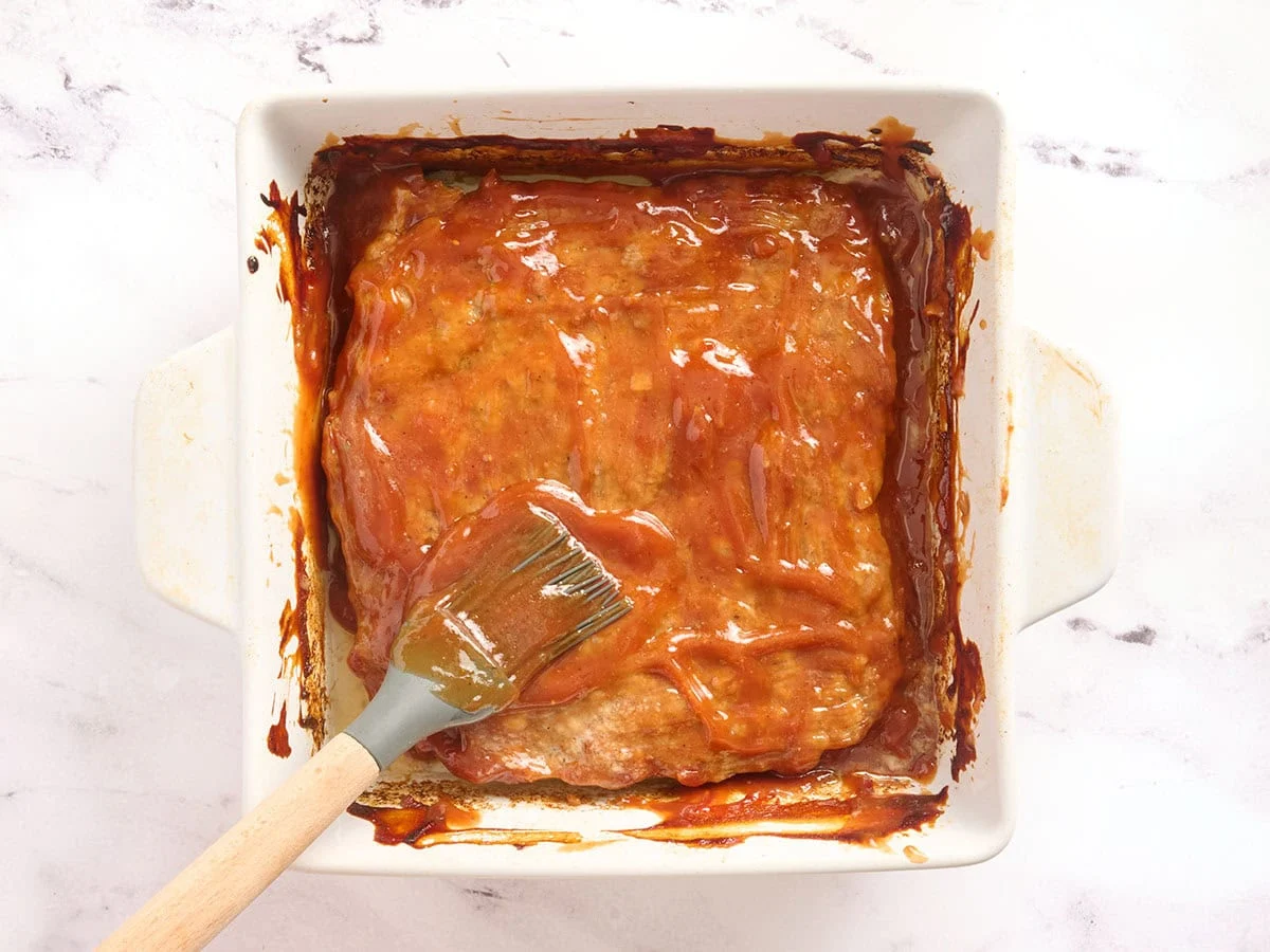 Cazuela de pastel de carne untada con glaseado después de hornearse en el horno.