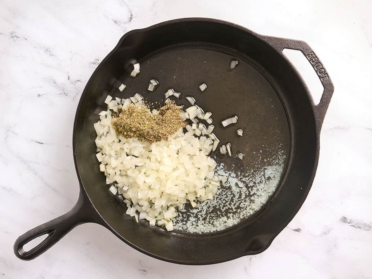 Mantequilla derretida, aceite, cebolla y hierbas secas en una sartén.