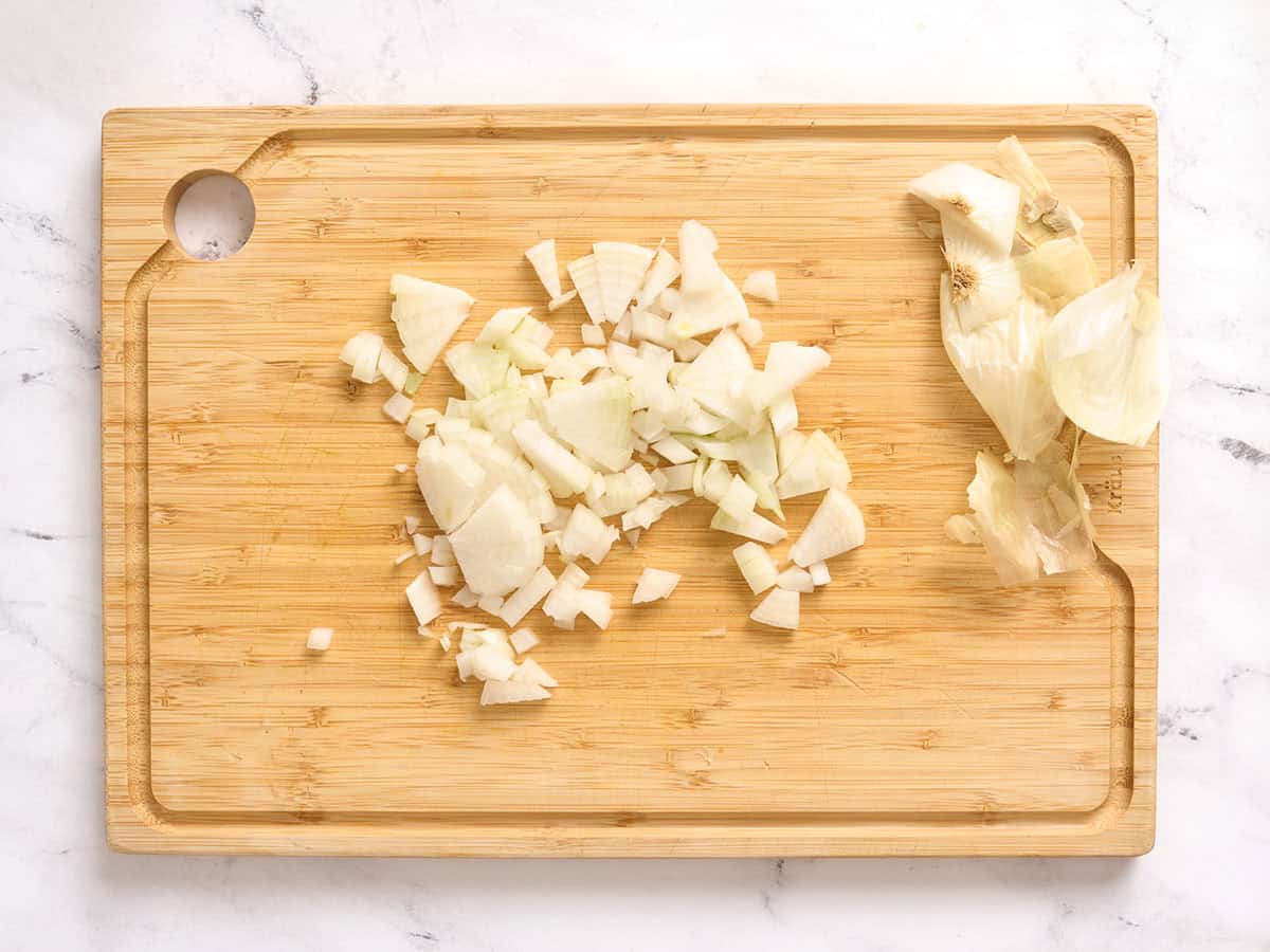 Cebolla picada sobre una tabla de cortar de madera.