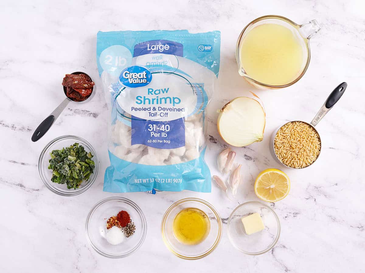 Los ingredientes para hacer una sartén de camarones al ajillo y orzo.