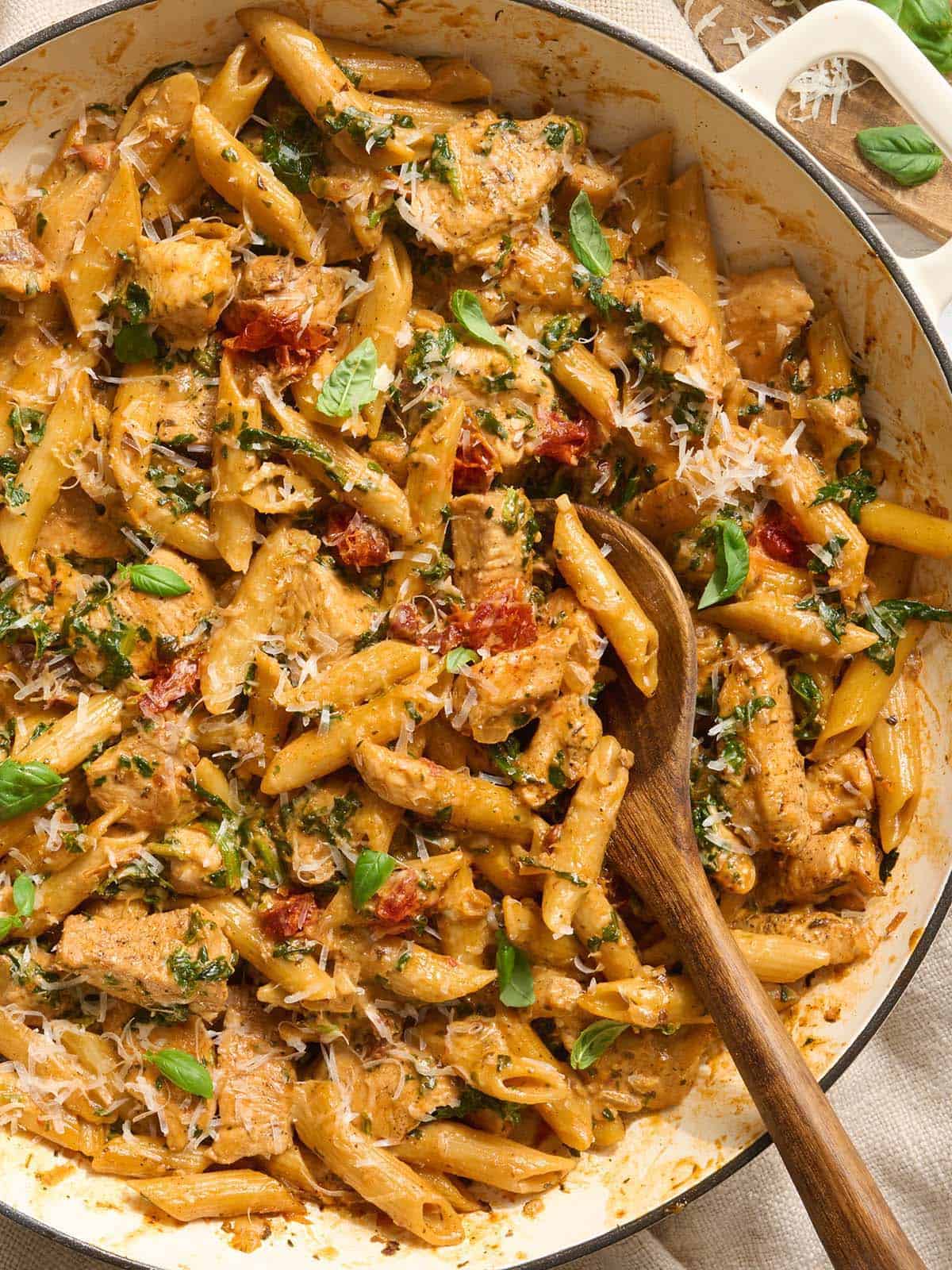 Arriba de cásate conmigo pasta de pollo en una olla con una cuchara de madera.