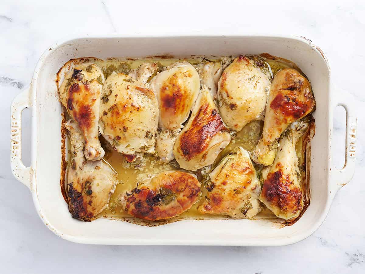 Pollo griego recién marinado en una fuente para horno.