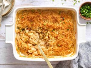 Overhead view of a million dollar chicken casserole in a casserole dish with a spoon.