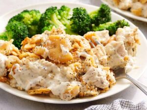 Side view of poppy seed casserole on a plate with broccoli.