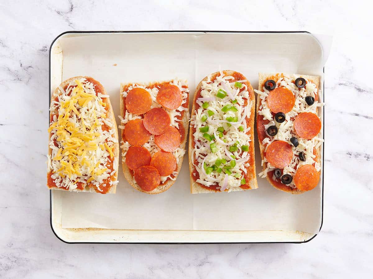 Coberturas añadidas a las pizzas caseras de pan francés.