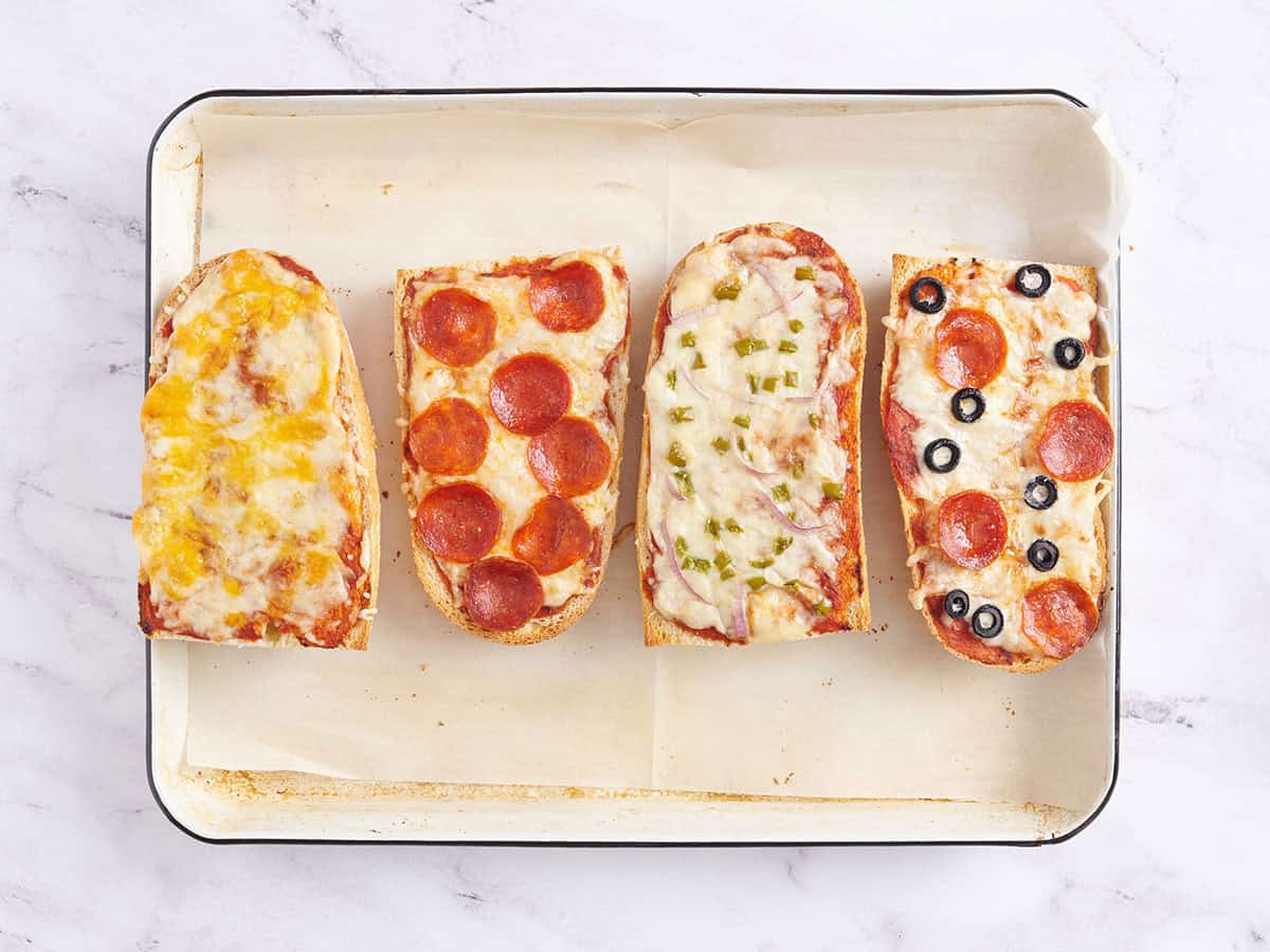 Pizzas rápidas de pan francés después de hornearlas en una bandeja para hornear.