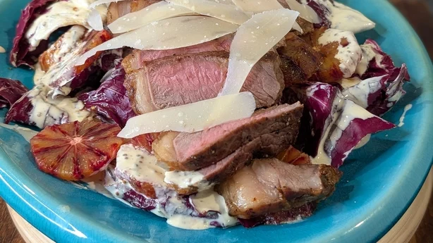 Un plato de bistec con queso y naranja sanguina