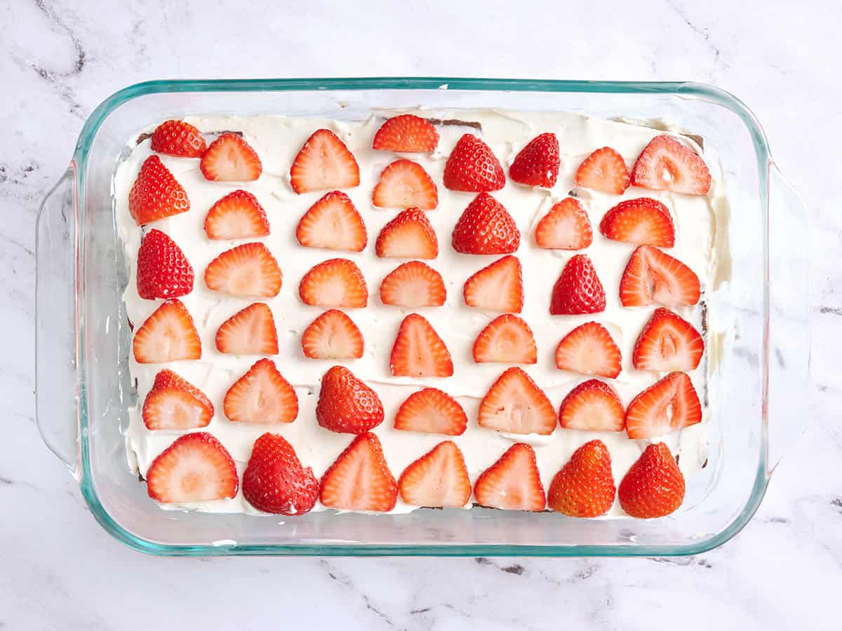 Fresas en capas sobre un pastel helado de chocolate.