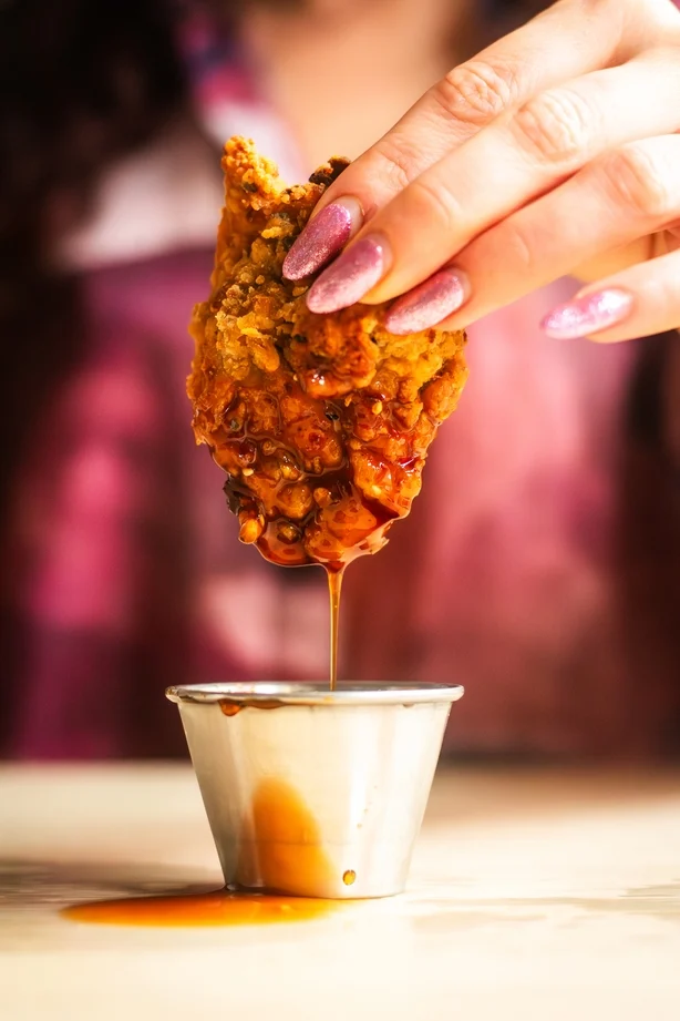 Primer plano de pollo frito bañado en salsa