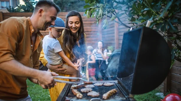 Una joven familia feliz celebrando una barbacoa en el patio trasero