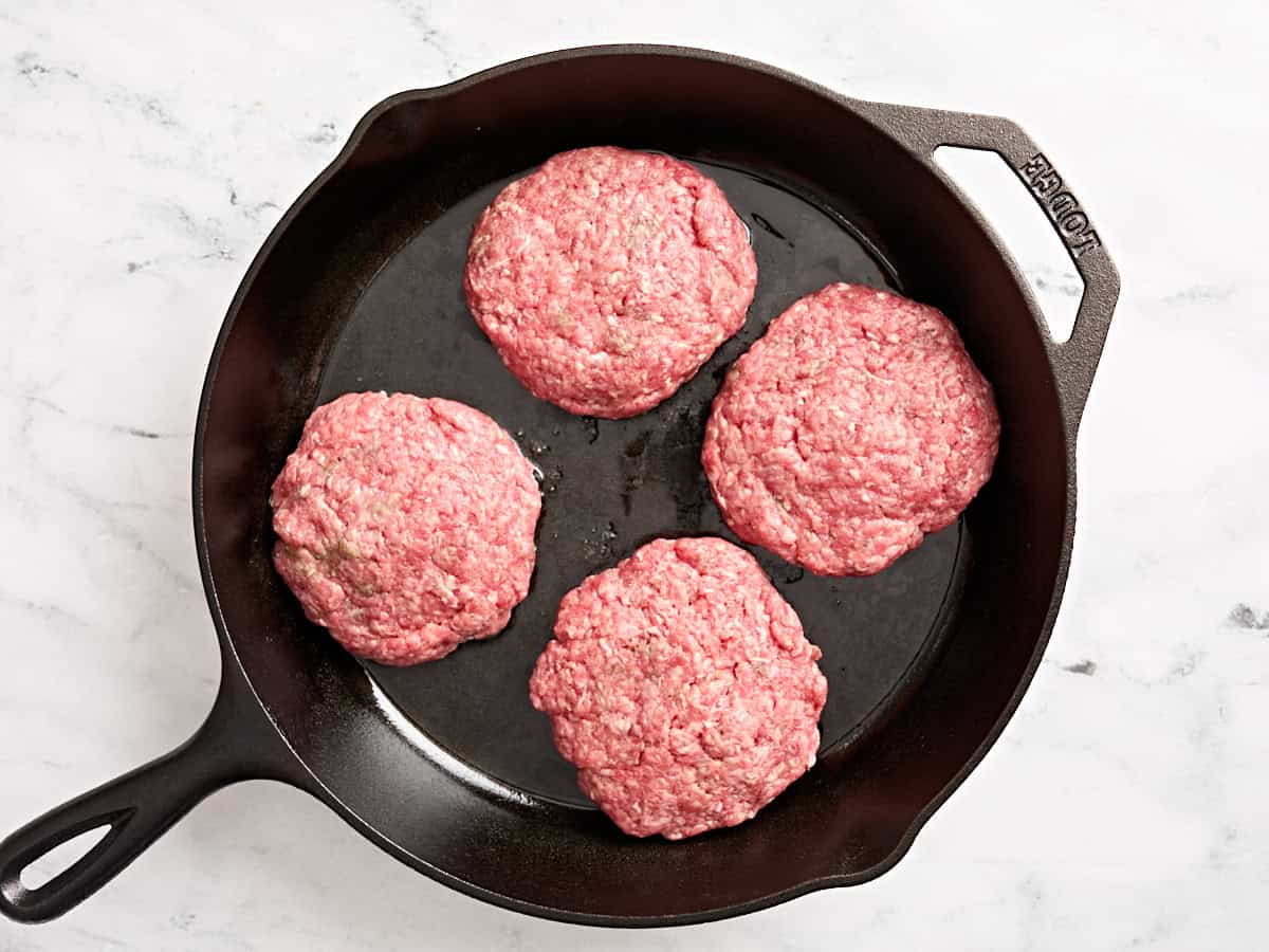 Jugosas hamburguesas Lucy cocinadas en una sartén.