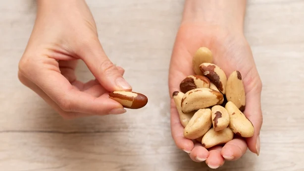 Mano de mujer sosteniendo nueces de Brasil