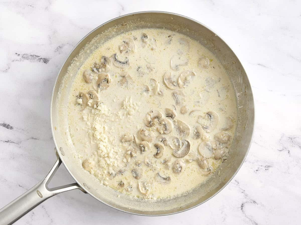 Queso parmesano agregado a una salsa cremosa de champiñones.