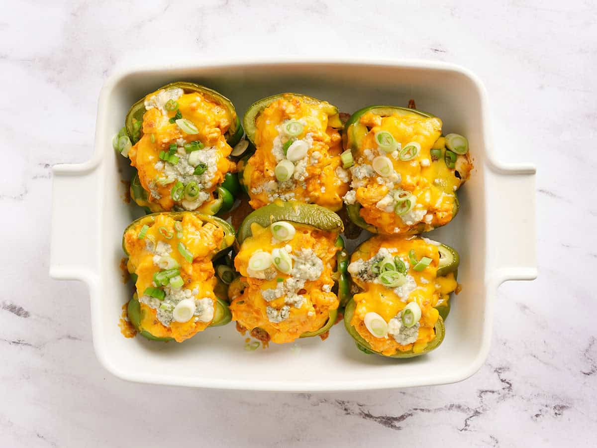 Pimientos rellenos de pollo Buffalo en una fuente para horno.