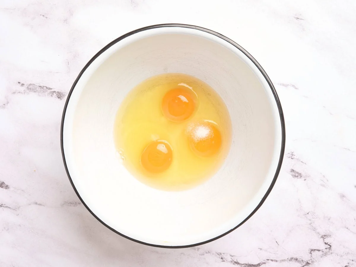 Tres huevos partidos en un tazón.