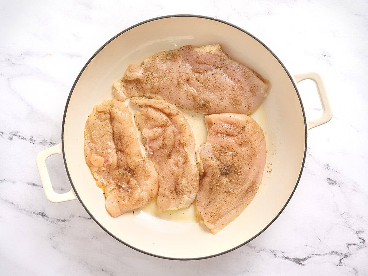 Chuletas de pechuga de pollo doradas en una sartén.