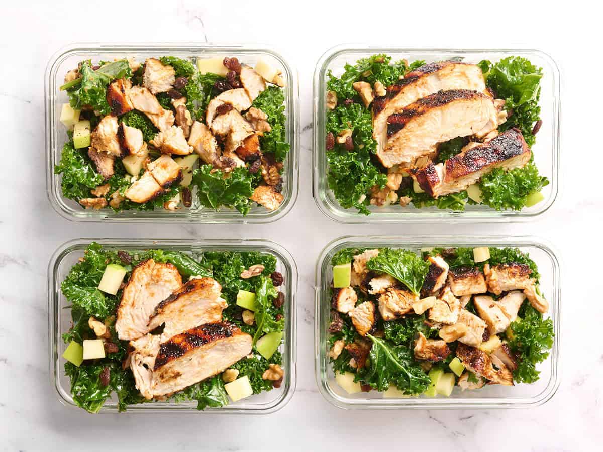 Vista aérea de una sencilla ensalada de col rizada con pollo asado en recipientes para preparar comidas.