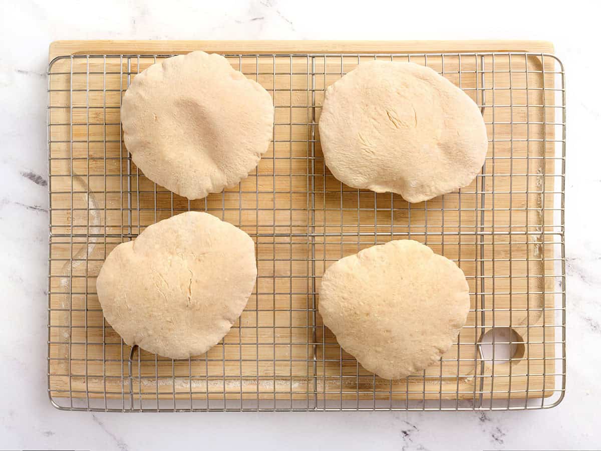 Pan de pita casero sobre una rejilla recién salido del horno.