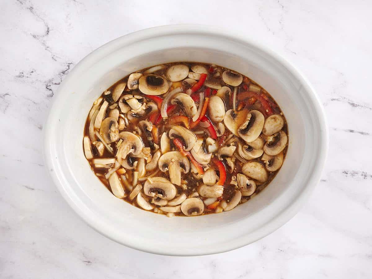 La base de caldo para ramen de pollo y verduras en olla de cocción lenta en una olla eléctrica.