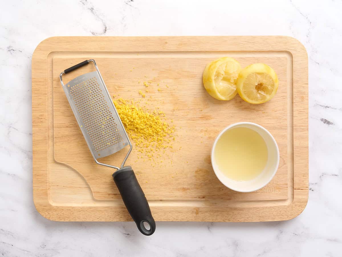 Jugo de limón y rallado sobre una tabla de cortar de madera.