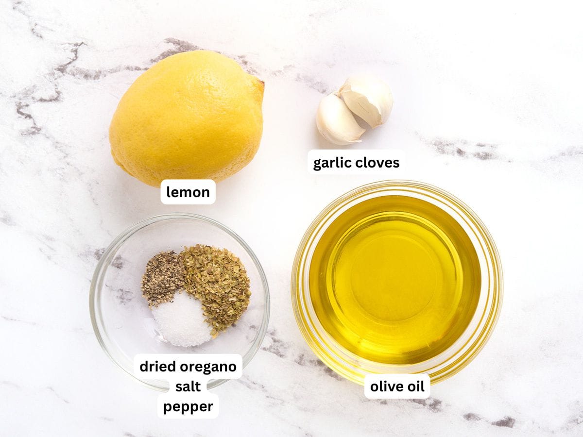 Los ingredientes para hacer un aderezo para ensalada de ajo y limón con etiquetas.