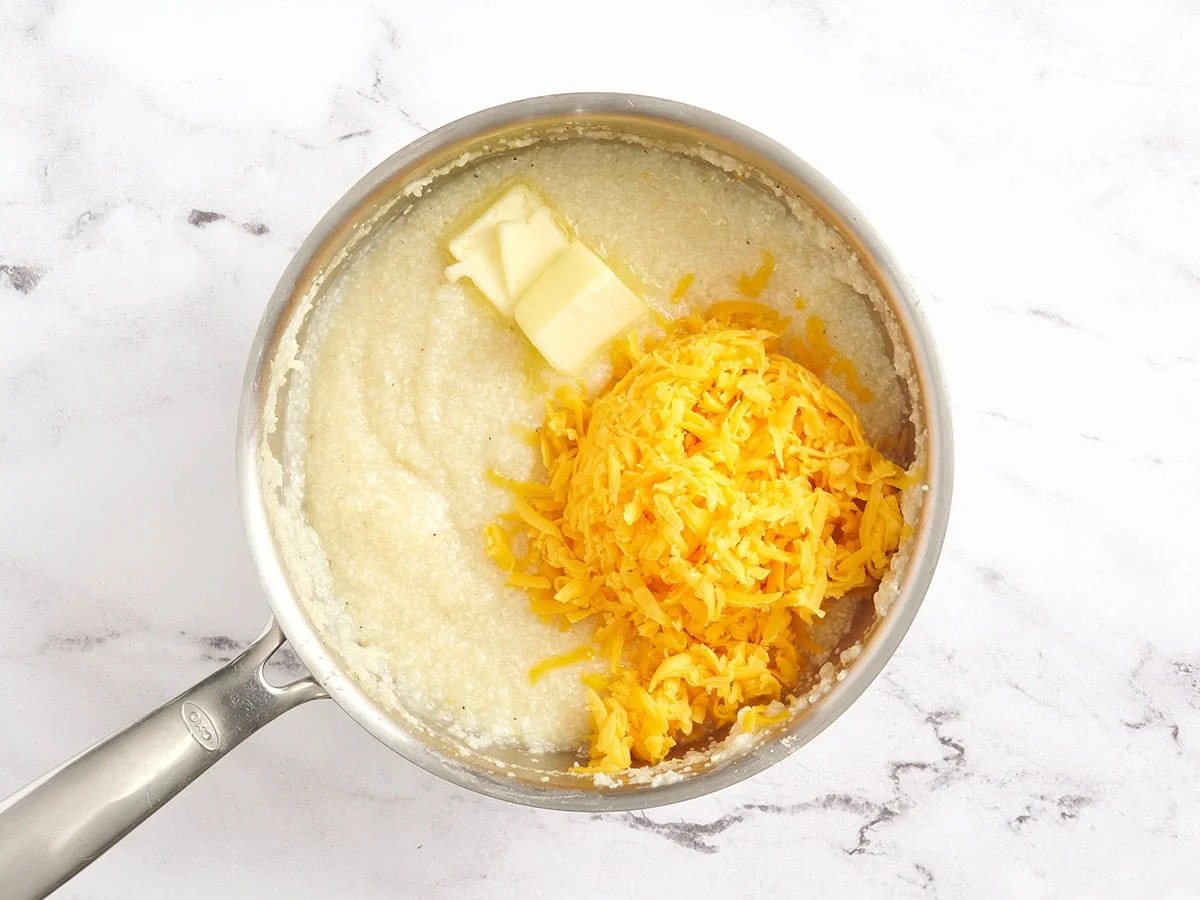 Se agrega queso rallado y mantequilla a una cacerola con sémola.