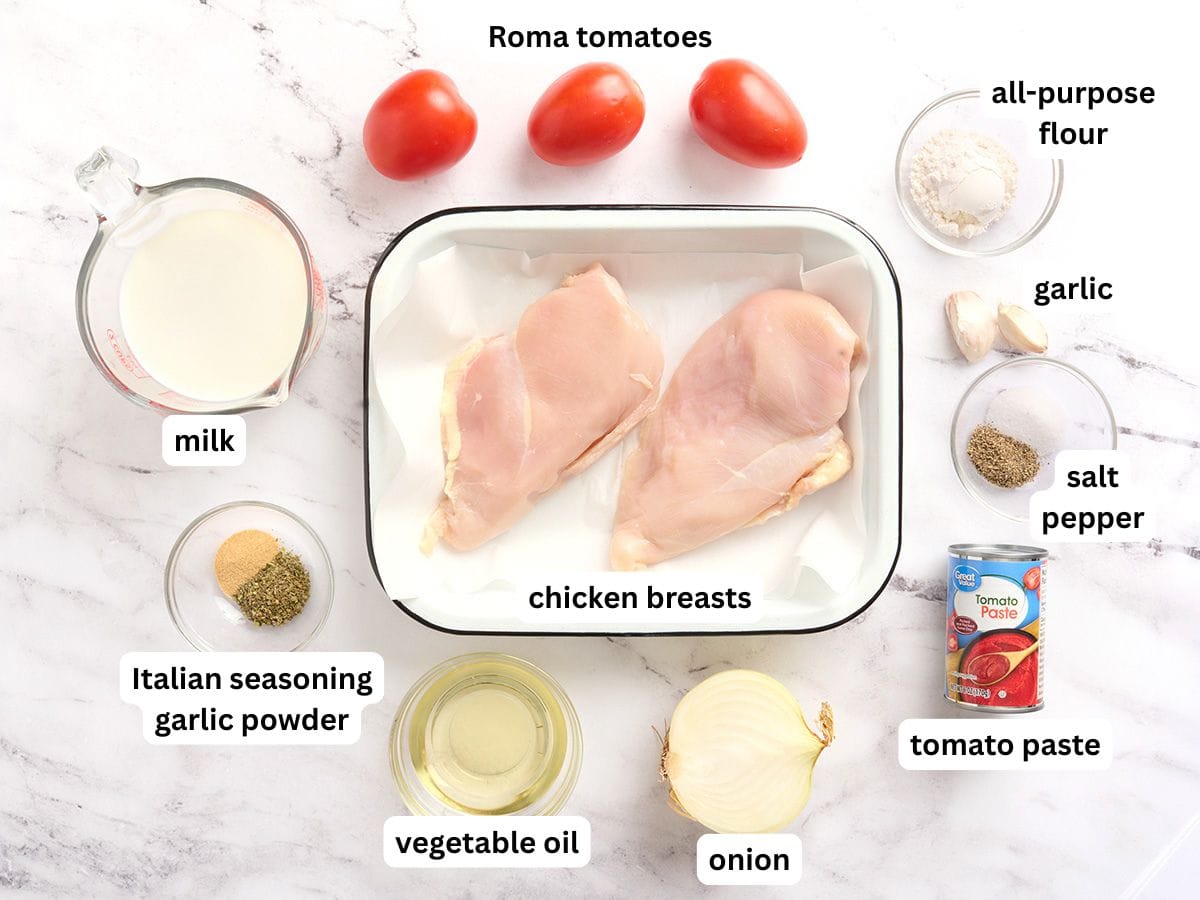 Los ingredientes para hacer pollo cremoso con tomate y etiquetas.