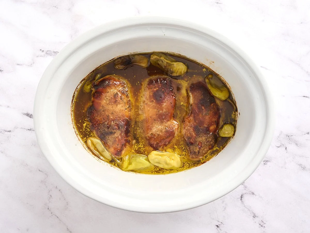 Pollo Mississippi en una olla de cocción lenta después de cocinarlo a temperatura alta.