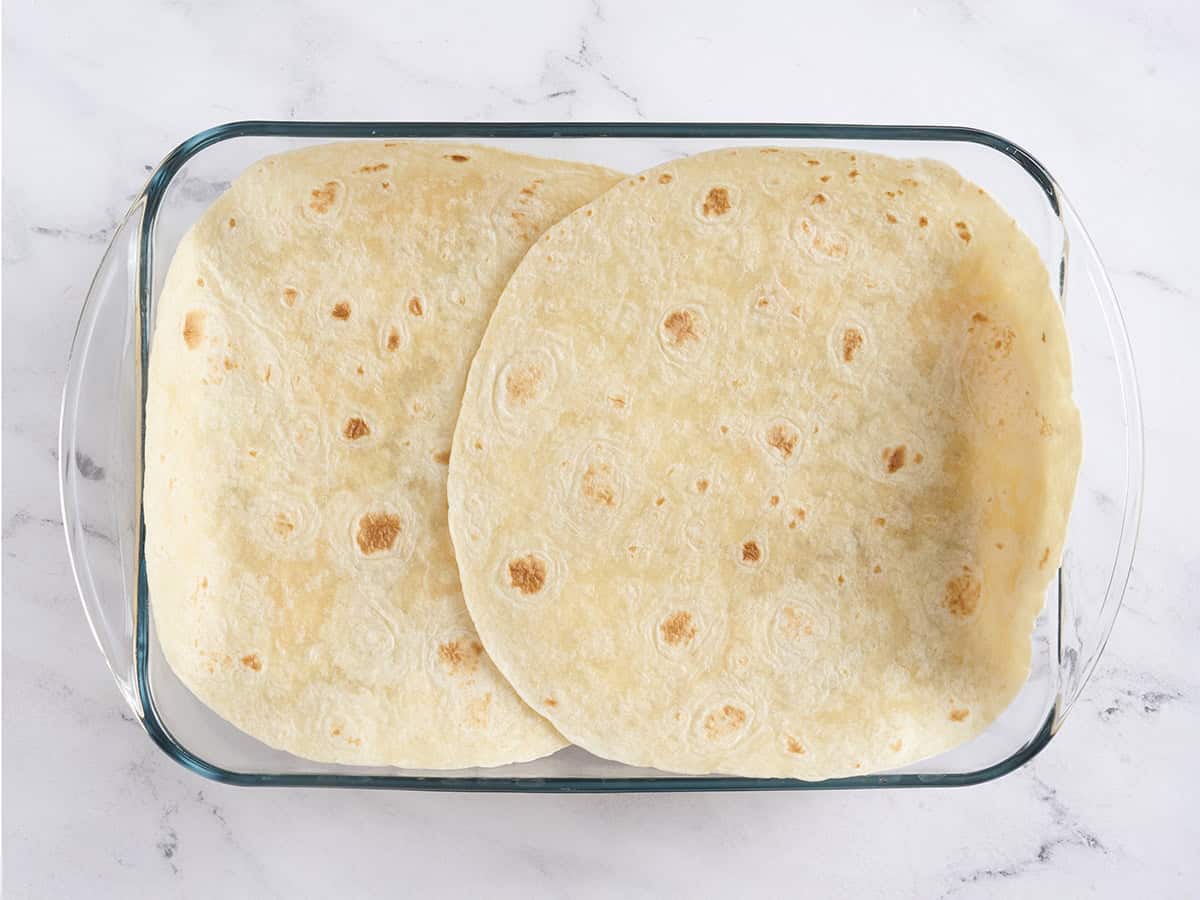 Se agregan dos tortillas grandes a una fuente para hornear.