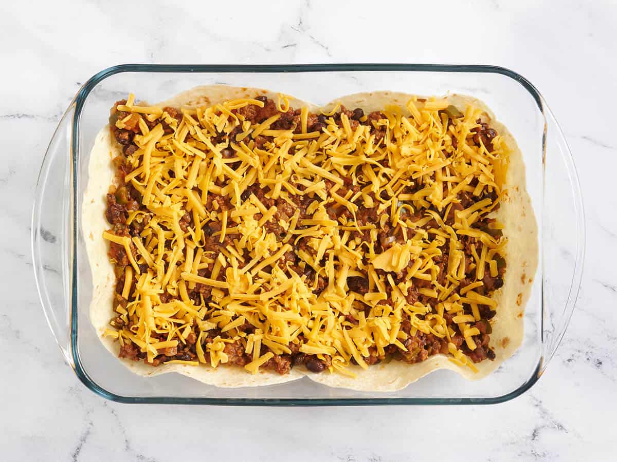 Queso agregado a una cazuela con carne para tacos y tortillas.