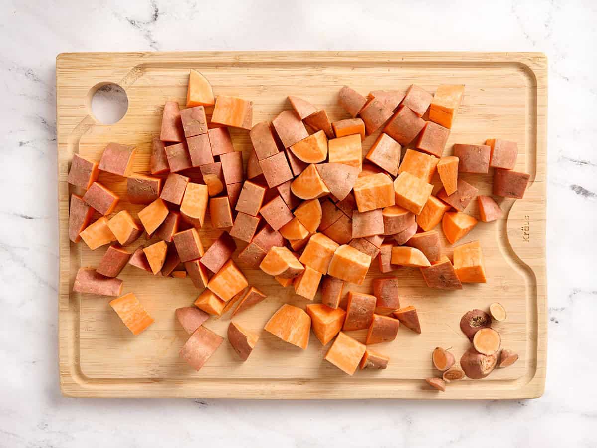 Batatas cortadas en cubitos sobre una tabla para cortar.