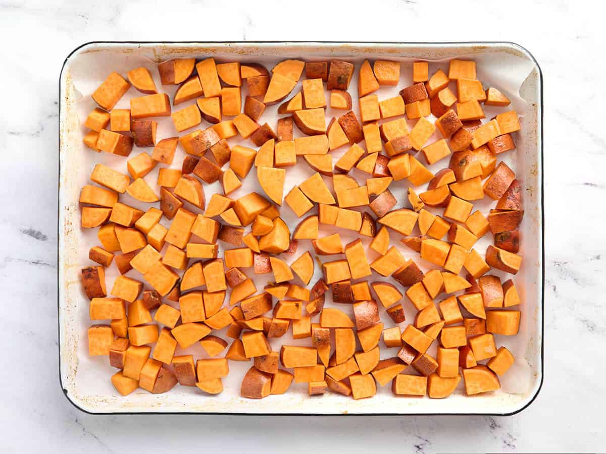 Batatas cortadas en cubitos en una bandeja para hornear.